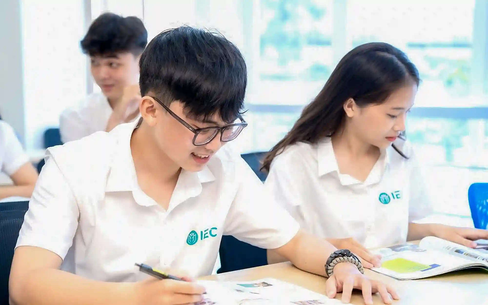 Sinh viên UTH chăm chỉ học tập trong lớp học, mặc đồng phục trắng với logo IEC